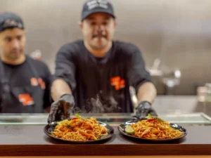 Thai Chefs Serving Fresh Pad Thai at Siam Bowl Amsterdam